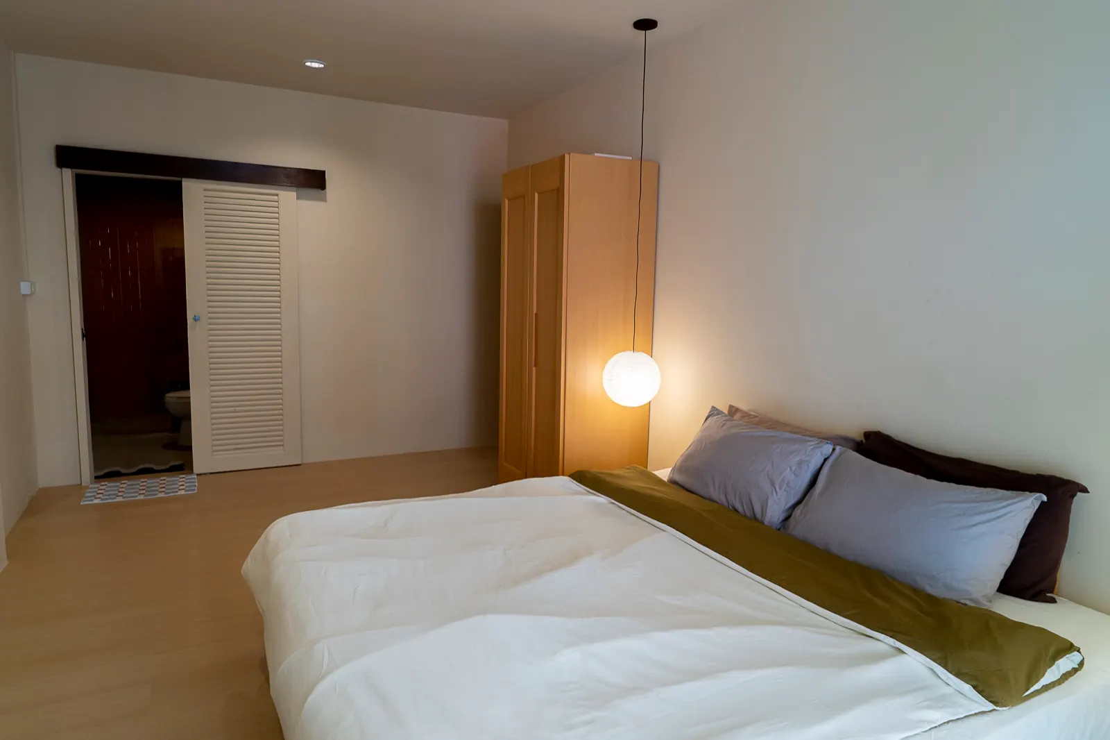Boutique minimalist guest room with king bed and warm lantern light