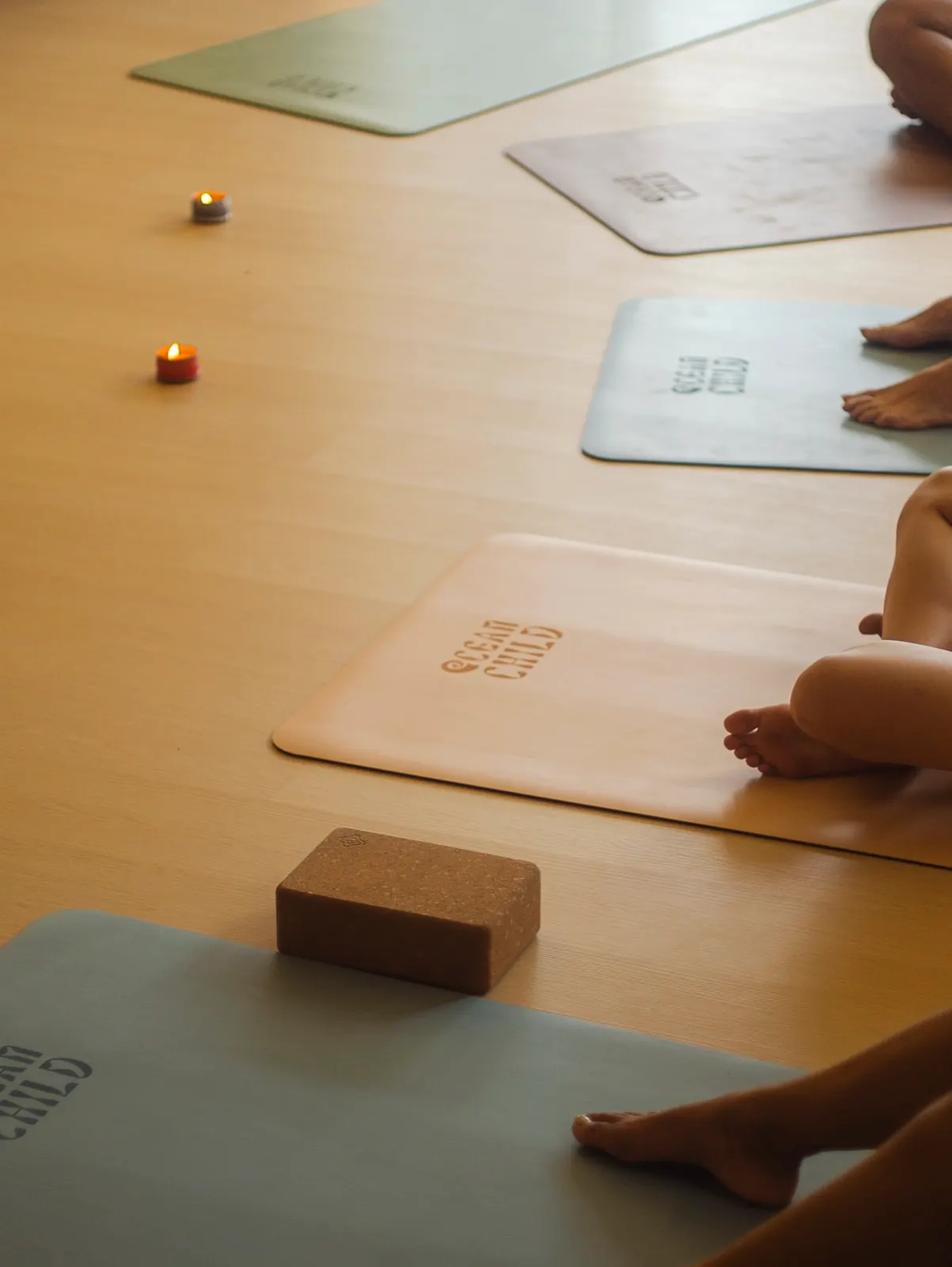 Mindful movement and breath practice on branded Oceanchild mats with candles and cork blocks